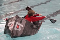 student competing in cardboard boat race