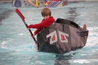 student competing in cardboard boat race