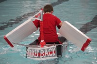 student competing in cardboard boat race