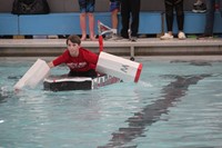 student competing in cardboard boat race