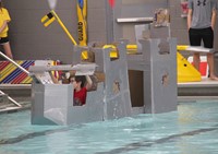 student competing in cardboard boat race