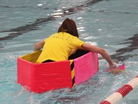 student competing in cardboard boat race