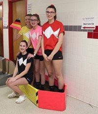 four students with cardboard boat