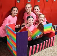 five students with cardboard boat
