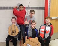 five students with cardboard boat