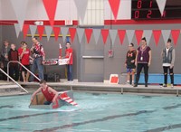 student competing in cardboard boat race