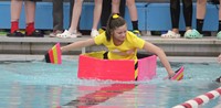 student competing in cardboard boat race