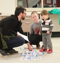 student and adult helping child with steam night activity 