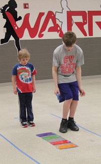 middle school student showing younger student how to complete activity