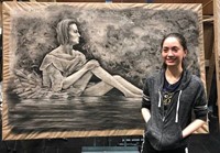 Kayla Ferris standing next to her finished artwork