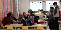 high school and middle school students reading to kindergarten students 8