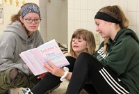 high school and middle school students reading to kindergarten students 7