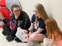 high school and middle school students reading to kindergarten students 3