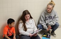 high school and middle school students reading to kindergarten students 1