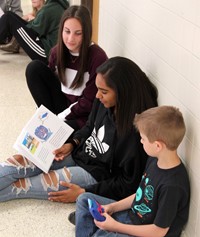 high school and middle school students reading to kindergarten students 6