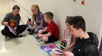 high school and middle school students reading to kindergarten students 4