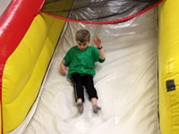 student going down inflatable slide