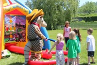 students watching mascot play inflatable baseball game