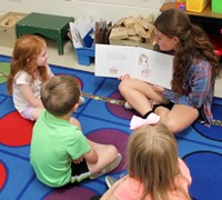 high school student reading to kindergarten students 5