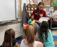 high school student reading to kindergarten students 2