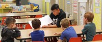 high school student reading to kindergarten students 1