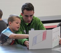 high school student reading to kindergarten students 19