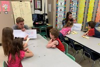 high school students reading to kindergarten students 