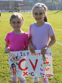 two students holding encouraging sign
