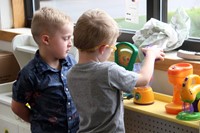 students playing in play kitchen