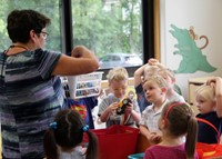 another photo of teacher showing students toys