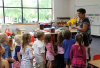 teacher showing students toys