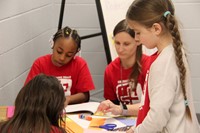 students and social worker taking part in kindness station