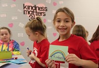 student holding kindness card