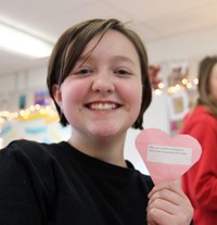 student smiling holding positive heart challenge