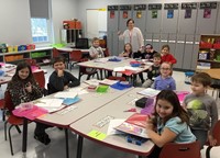 students and teacher smiling in classroom