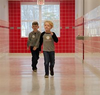 two students walking through hallway