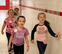 four students walking through hallway