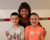 principal smiling with two students