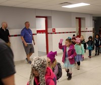 students waving in hallway