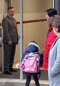 adults greeting students