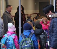 adults greeting students