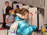 students putting items in cubbies