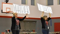 teachers holding up signs that read whatever it takes