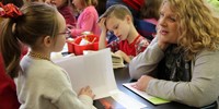 student reading to assistant superintendent