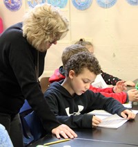 student reading to adult at writing celebration