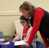 student reading to adult