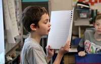 student reading story to classroom