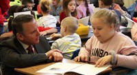 student reading to superintendent