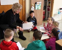 students reading with adult