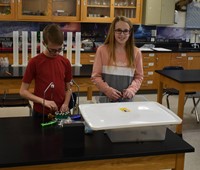 two students taking part in science activity
